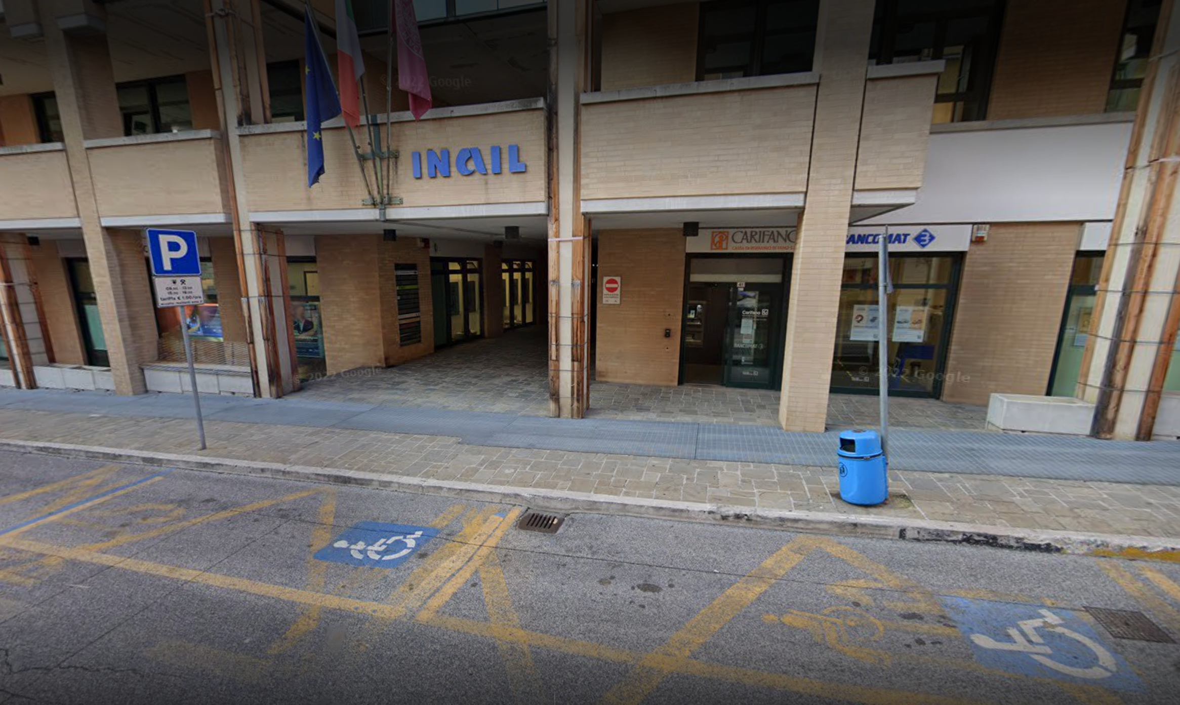 l'immagine rappresenta due parcheggi riservati alle persone disabili davanti all'ingresso del centro direzionale
